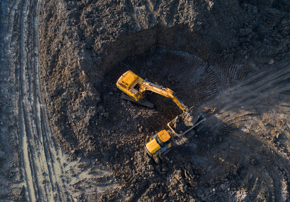 Aerial drone view of excavator loading a truck.